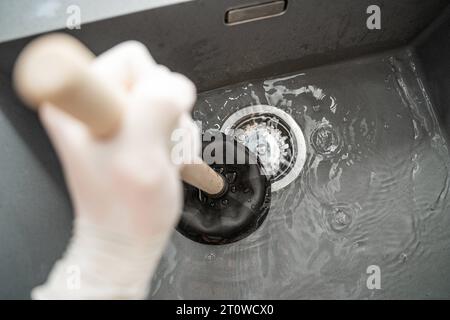 Augsbourg, Bavière, Allemagne. 29 septembre 2023. Workman tente de résoudre un blocage dans un évier avec une cloche d'aspiration *** Handwerker versucht eine Verstopfung in einem Waschbecken mit einer Saugglocke zu lösen Credit : Imago/Alamy Live News Banque D'Images