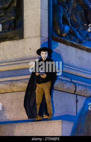 Million Mask March London, par Anonymous pour les sans-voix. Activiste portant le masque V pour Vendetta coiffé sur Guy Fawkes, sur la colonne de Nelson Banque D'Images
