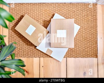 Pile de colis en carton livrés sur un tapis de porte à côté de l'entrée de l'appartement Banque D'Images