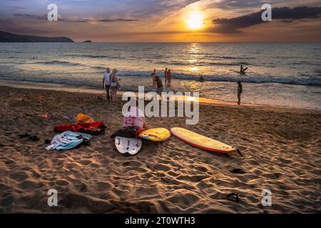 Vacanciers profitant d'un coucher de soleil spectaculaire sur la baie de Fistral à Newquay en Cornouailles au Royaume-Uni en Europe. Banque D'Images