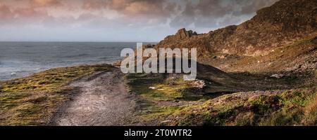 Une image panoramique de la lumière du soir sur un sentier accidenté sur le point est accidenté de Pintre sur la côte de Newquay en Cornouailles en Angleterre au Royaume-Uni. Banque D'Images