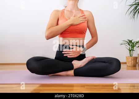 Exercice de respiration de méditation. Personne féminine portant des vêtements de sport assis dans la pose de yoga lotus et méditant. Banque D'Images