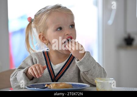 Petite fille, 2 ans, blonde, mange des crêpes, crêpe, assiette, cuillère, manger, Stuttgart, Baden-Wuerttemberg, Allemagne Banque D'Images