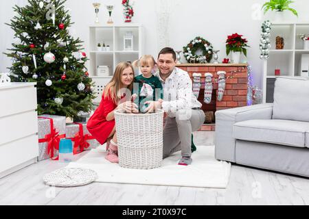 Famille heureuse passe Noël ensemble dans une maison décorée Banque D'Images