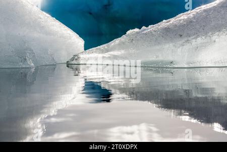 Gros plan de deux icebergs reflétés dans une eau calme, Jokulsarlon Glacier Lagoon, Islande Banque D'Images