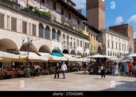 Vérone, Italie-12 juin 2023 ; Piazza delle Erbe place de la ville avec marché et entouré de cafés et de bâtiments historiques comme Palazzo della Ragione Banque D'Images