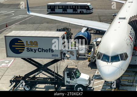 Aéroport JFK, NY, États-Unis - 11 juillet 2023 ; camion de restauration de l'aéroport à côté d'un avion Delta pour l'approvisionnement alimentaire avec un membre du personnel au sol poussant la restauration Banque D'Images