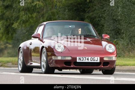 Bicester, Oxon., Royaume-Uni - 8 octobre 2023 : 1996 rouge Porsche 911 Carrera voiture classique conduisant sur une route de campagne anglaise. Banque D'Images