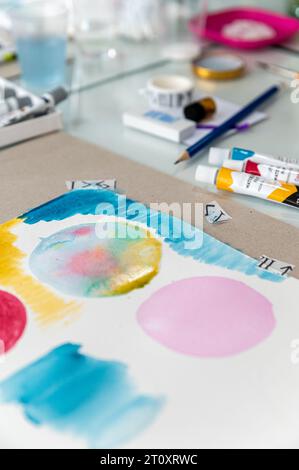 Cette photo en gros plan d'une aquarelle sur une table montre un design abstrait beau et coloré. La peinture est pleine de couleurs vibrantes. Banque D'Images