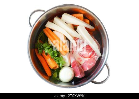 Ingrédients pour soupe de boeuf dans le pot isolé sur fond blanc. Viande et légumes préparés pour la cuisson de la soupe de bœuf. Vue de dessus. Banque D'Images