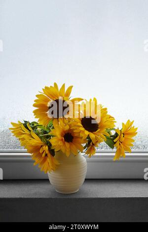 Tournesols frais dans un vase sur le rebord de la fenêtre. Nature morte festive d'automne. Banque D'Images