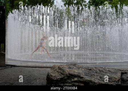 Deux filles jouent dans une fontaine. Vue d'œuvres d'art au musée Kistefos, un jardin de sculptures en plein air près de Jevnaker, Viken, Norvège. Banque D'Images