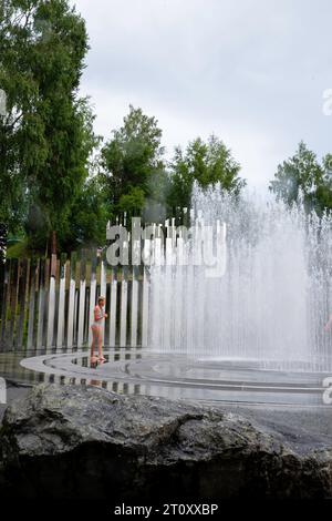 Deux filles jouent dans une fontaine. Vue d'œuvres d'art au musée Kistefos, un jardin de sculptures en plein air près de Jevnaker, Viken, Norvège. Banque D'Images