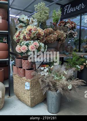 Fleurs et bouquets imitation fabriqués à partir de matériaux recyclés, exposés dans un centre de jardinage. Concept de décoration intérieure avec des produits recyclés. Banque D'Images