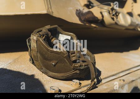 Casque militaire de couleur foncée couché à l'envers sur un char militaire américain. Équipement militaire moderne. Photo de haute qualité Banque D'Images