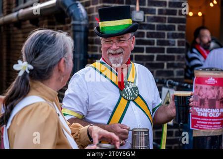 Un Morris Man du côté long Man Morris Men discutant avec Une femme à l'événement 'Dancing in the Old', Lewes, East Sussex, Royaume-Uni Banque D'Images