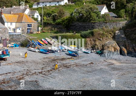 Cadgwith Cove village de pêcheurs en Cornouailles, deux pêcheurs travaillant sur le port de plage ci-dessous, Angleterre, Royaume-Uni, 2023 Banque D'Images