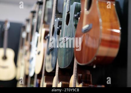 Guitares acoustiques accrochées à un mur dans un magasin de musique. Mise au point sélective. Banque D'Images