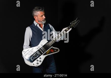 Stephen Lane, PDG de Propstore, tient un Paul Stanley de KISS autographié et inscrit sur scène, utilisé sur mesure la guitare Washburn StarFire à paillettes argentées (estimation de £40 000 - 80.000) lors d'une avant-première pour la Entertainment Memorabilia Auction, au Propstore de Rickmansworth, Hertfordshire. Date de la photo : mercredi 20 septembre 2023. Banque D'Images