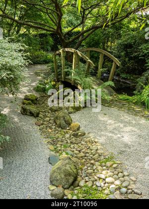 Jardin de style Zen japonais avec du gravier ratissé, pont et rivière en bois orné de galets, le Barnsdale Jardins, Rutland, England, UK. Banque D'Images