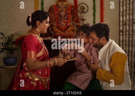 Famille Maharashtrian adorant le Seigneur Ganesha à l'occasion de Ganesh Chaturthi Banque D'Images