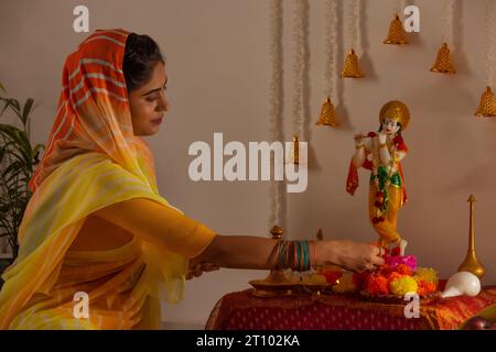 Femme adorant le Seigneur Krishna à l'occasion de Janmashtami Banque D'Images