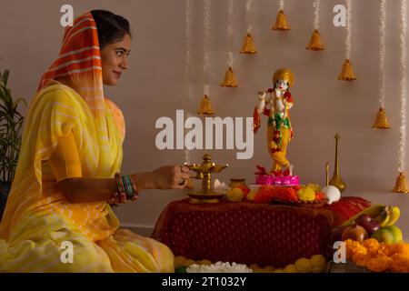 Femme adorant le Seigneur Krishna à l'occasion de Janmashtami Banque D'Images