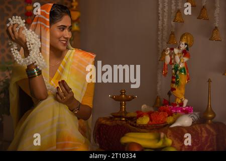 Femme adorant le Seigneur Krishna à l'occasion de Janmashtami Banque D'Images