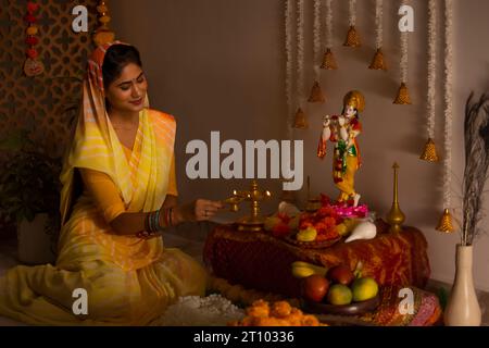 Femme adorant le Seigneur Krishna à l'occasion de Janmashtami Banque D'Images