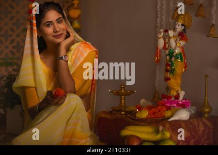 Femme adorant le Seigneur Krishna à l'occasion de Janmashtami Banque D'Images