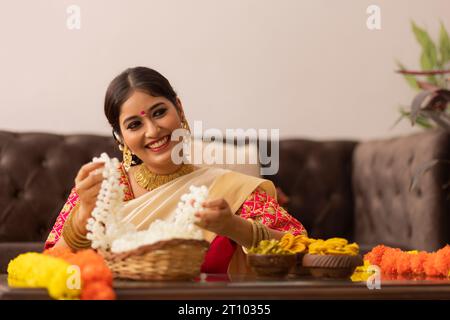 Femme indienne du Sud dans des fleurs saurées blanches pour célébrer Onam Banque D'Images