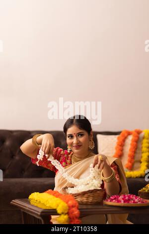 Femme indienne du Sud dans des fleurs saurées blanches pour célébrer Onam Banque D'Images