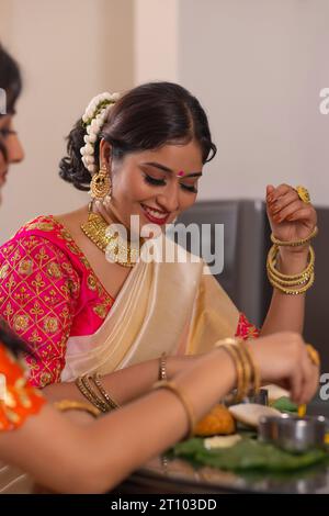 Des femmes heureuses ayant Onam Sadhya ensemble à la maison Banque D'Images