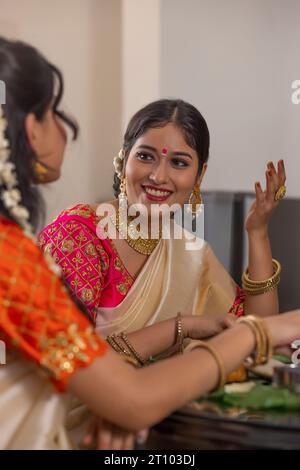 Des femmes heureuses ayant Onam Sadhya ensemble à la maison Banque D'Images