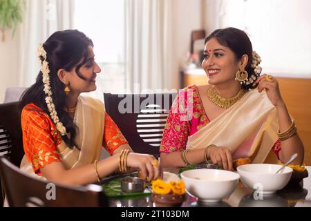 Des femmes heureuses ayant Onam Sadhya ensemble à la maison Banque D'Images