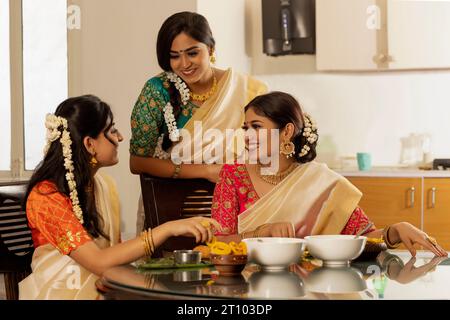 Des femmes heureuses ayant Onam Sadhya ensemble à la maison Banque D'Images