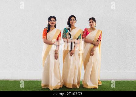 Femmes indiennes du Sud en saree blanc debout ensemble et regardant la caméra Banque D'Images