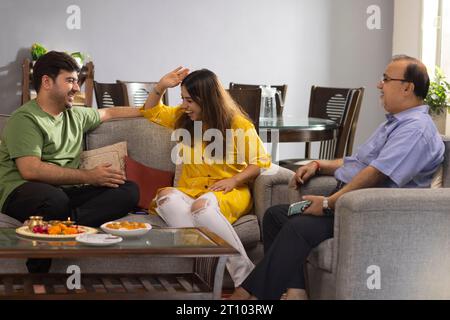 Famille indienne heureuse assis ensemble à la maison et parlant les uns aux autres sur Raksha Bandhan Banque D'Images