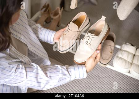 Femme moderne choisissant des chaussures mettant sur une armoire rack rangement confortable organisant vue de dessus Banque D'Images