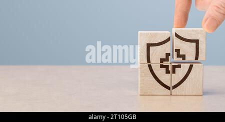 Concept d'assurance maladie. Main mettant bloc de cube en bois médical de soins de santé avec icône, santé et concept d'assurance. Protection, traitement et prévention Banque D'Images