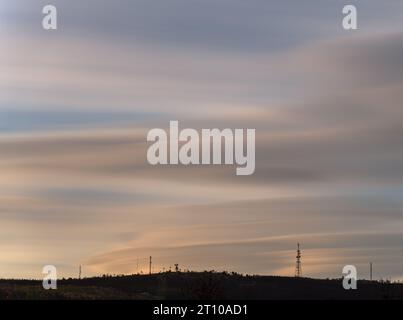 Longue exposition du pic de montagne plat avec antennes de communication au coucher du soleil Banque D'Images