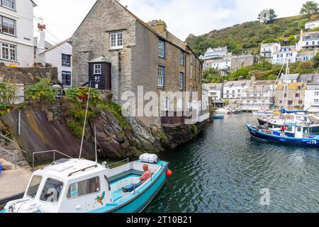 Septembre 2023, Polperro village de pêcheurs en Cornouailles, bateaux de pêche amarrés dans les cottages en pierre du port entourent le port, Angleterre, Royaume-Uni Banque D'Images