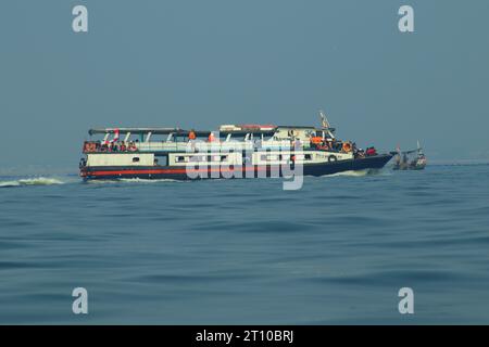 navires à passagers et bateaux de pêche, également visibles au-dessus du vaste océan. sur fond de mer bleue et de nuages bleus. Banque D'Images