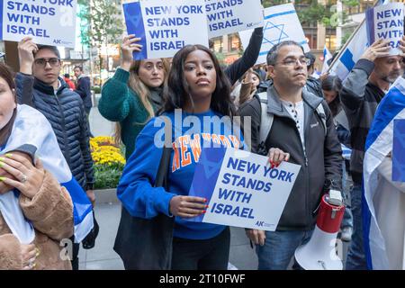 Des partisans d'Israël avec des drapeaux israéliens, des drapeaux américains et des pancartes se rassemblent lors d'une veillée aux chandelles pour les victimes d'attaques terroristes en Israël sur la place Golda Meir de Manhattan à New York. Le 7 octobre, le groupe militant palestinien Hamas a lancé une attaque surprise contre Israël depuis Gaza par terre, mer et air, tuant plus de 900 personnes et en blessant plus de 2000. Selon certaines informations, 130 soldats et civils israéliens ont également été enlevés par le Hamas et emmenés à Gaza. L'attaque a provoqué une déclaration de guerre par le Premier ministre israélien Benjamin Netanyahu, et des frappes de représailles continues de l'EI Banque D'Images