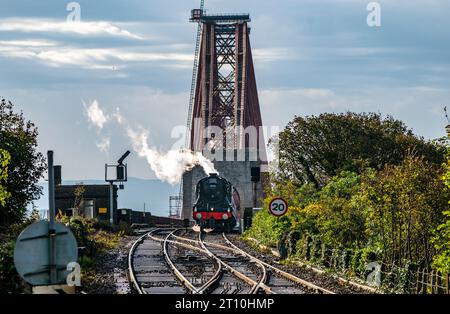 Le Flying Scotsman passe au-dessus du Forth Bridge près de North Queensferry, Fife, en Écosse. La locomotive à vapeur la plus célèbre au monde célèbre son centenaire, entrée en service le 24 février 1923. Ses réalisations comprennent le transport du premier train sans escale de Londres à Édimbourg en 1928, et devenir la première locomotive du Royaume-Uni à atteindre 100 km/h six ans plus tard. Date de la photo : mardi 10 octobre 2023. Banque D'Images