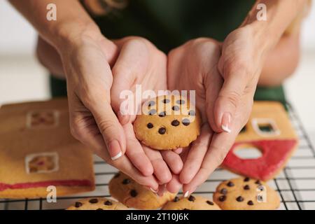 Mains de la mère et de la fille tenant le biscuit qu'ils ont cuit pour Noël Banque D'Images
