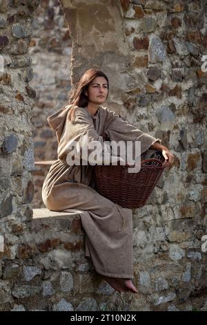 Collectionneur médiéval avec panier se trouve dans le château Banque D'Images