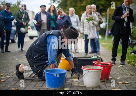 10 octobre 2023, Saxe-Anhalt, Magdebourg : l'artiste Gunter Demnig pose Stolpersteine sur un trottoir. Stolpersteine sont des blocs de béton de dix par dix centimètres avec une plaque de laiton intégrée dans laquelle les noms et les données biographiques des victimes du national-socialisme, la date de la déportation et le lieu de la déportation sont gravés et sont incrustés dans le sol devant les anciennes maisons. Au total, 19 Stolpersteine seront posées à Magdebourg pendant la journée. Photo : Klaus-Dietmar Gabbert/dpa Banque D'Images