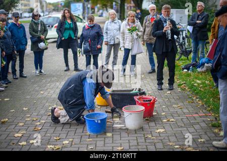 10 octobre 2023, Saxe-Anhalt, Magdebourg : l'artiste Gunter Demnig pose Stolpersteine sur un trottoir. Stolpersteine sont des blocs de béton de dix par dix centimètres avec une plaque de laiton intégrée dans laquelle les noms et les données biographiques des victimes du national-socialisme, la date de la déportation et le lieu de la déportation sont gravés et sont incrustés dans le sol devant les anciennes maisons. Au total, 19 Stolpersteine seront posées à Magdebourg pendant la journée. Photo : Klaus-Dietmar Gabbert/dpa Banque D'Images