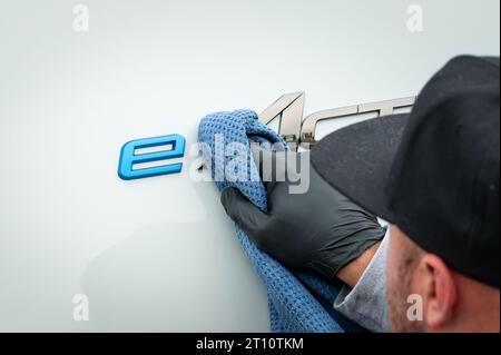 Egestorf, Allemagne. 10 octobre 2023. Un employé nettoie le logo du nouveau camion longue distance « eActros 600 » à l'arrêt « Hamburg-Nordheide » avant la présentation. Le constructeur de véhicules utilitaires Daimler Truck a présenté la version série de son camion long-courrier électrique à batterie, le Mercedes-Benz eActros 600. Crédit : Jonas Walzberg/dpa/Alamy Live News Banque D'Images